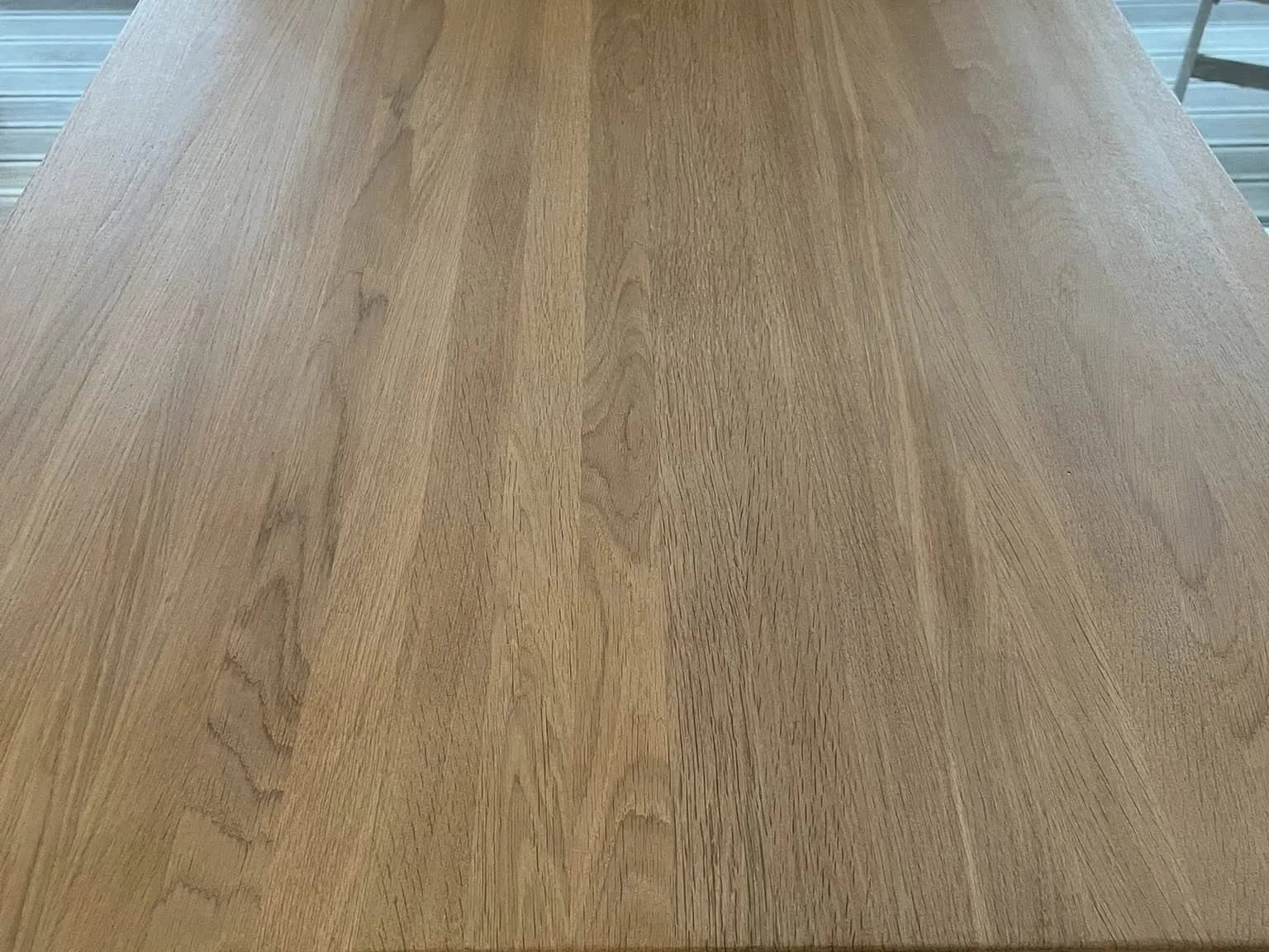 Samma träbänkskiva efter slipning och ytbehandling: jämnare yta vid disk och bänk.