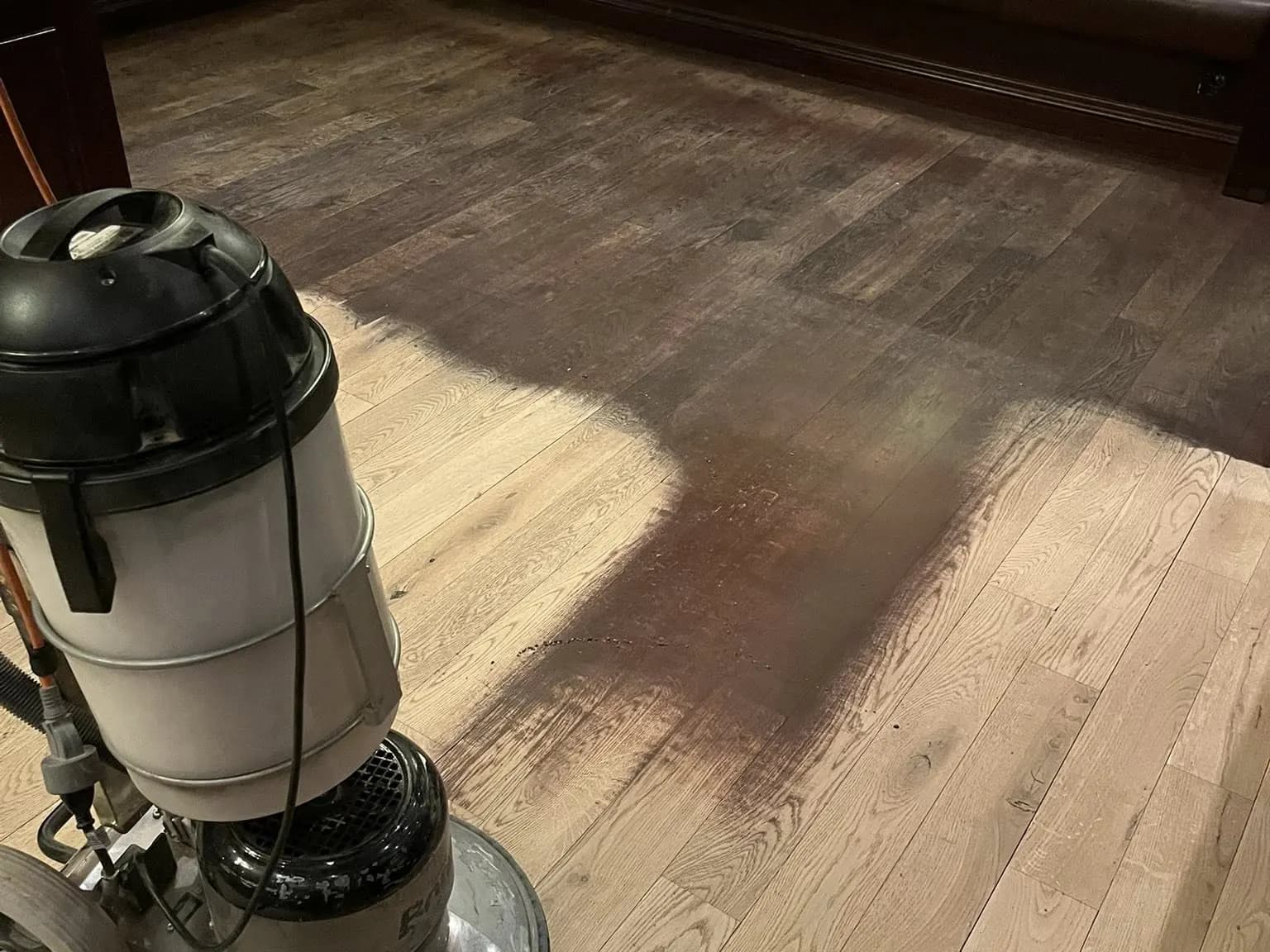 Slitet trägolv i restaurangmiljö före renovering: märken och ojämn finish.