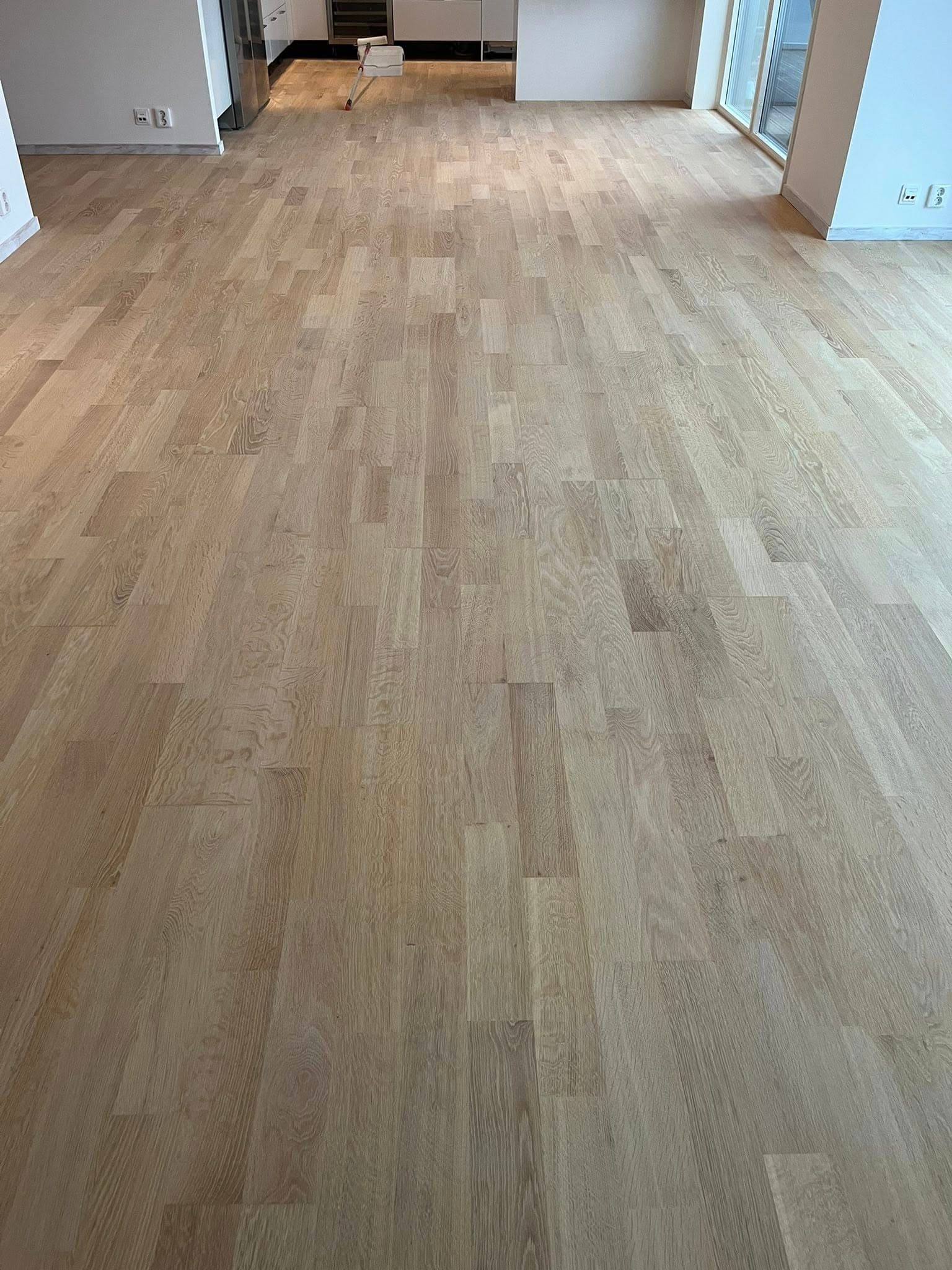 Köksgolv efter slipning och ytbehandling: jämnare yta och tydligare träkaraktär.