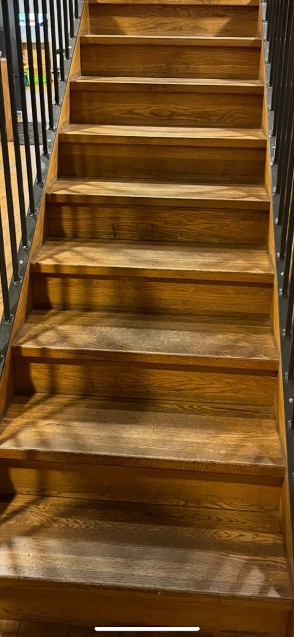 Trätrappa före behandling: matta steg med slitage och fläckar.