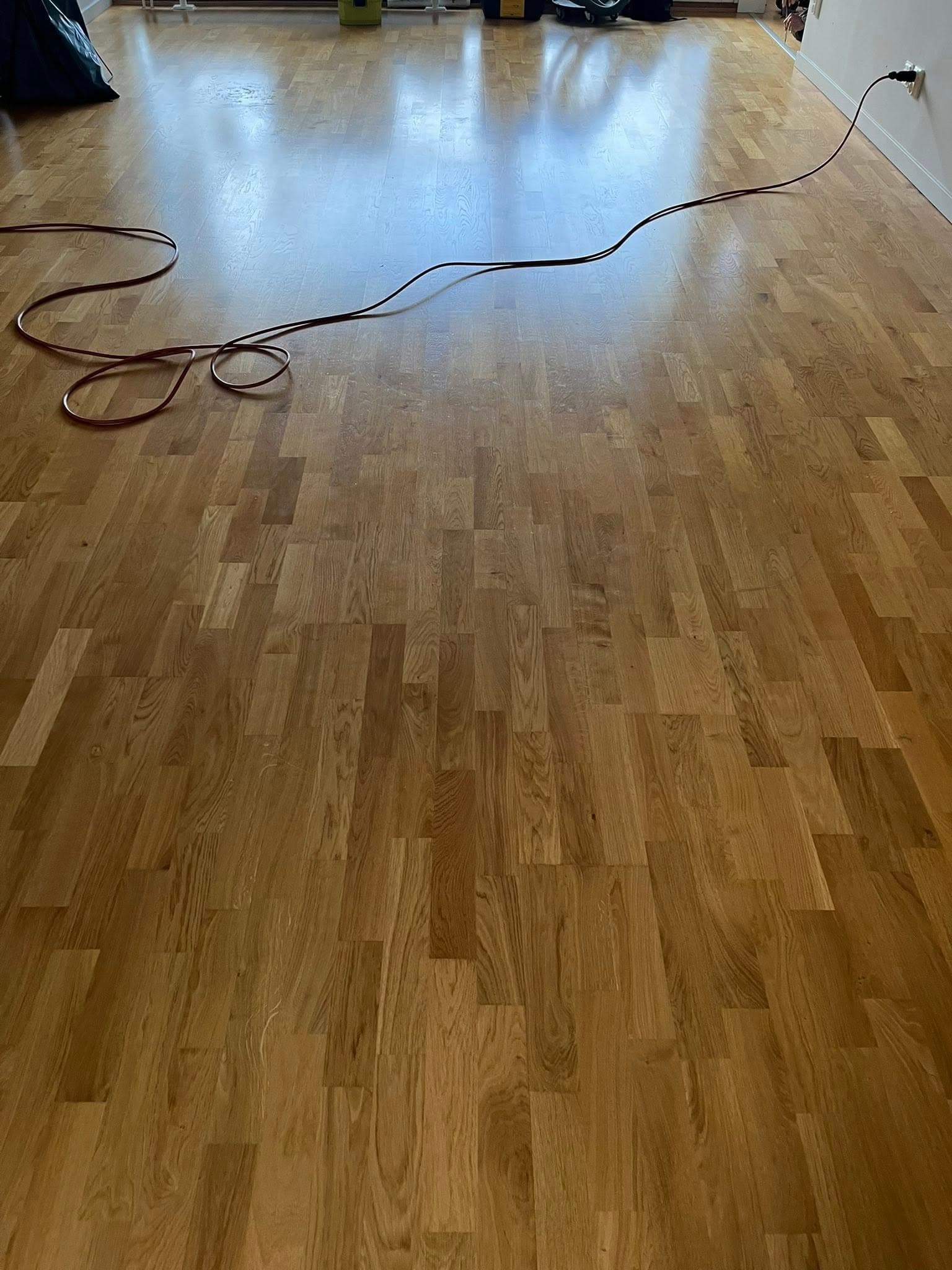 Parkett eller plankgolv före slipning: ojämn yta och fläckiga partier.