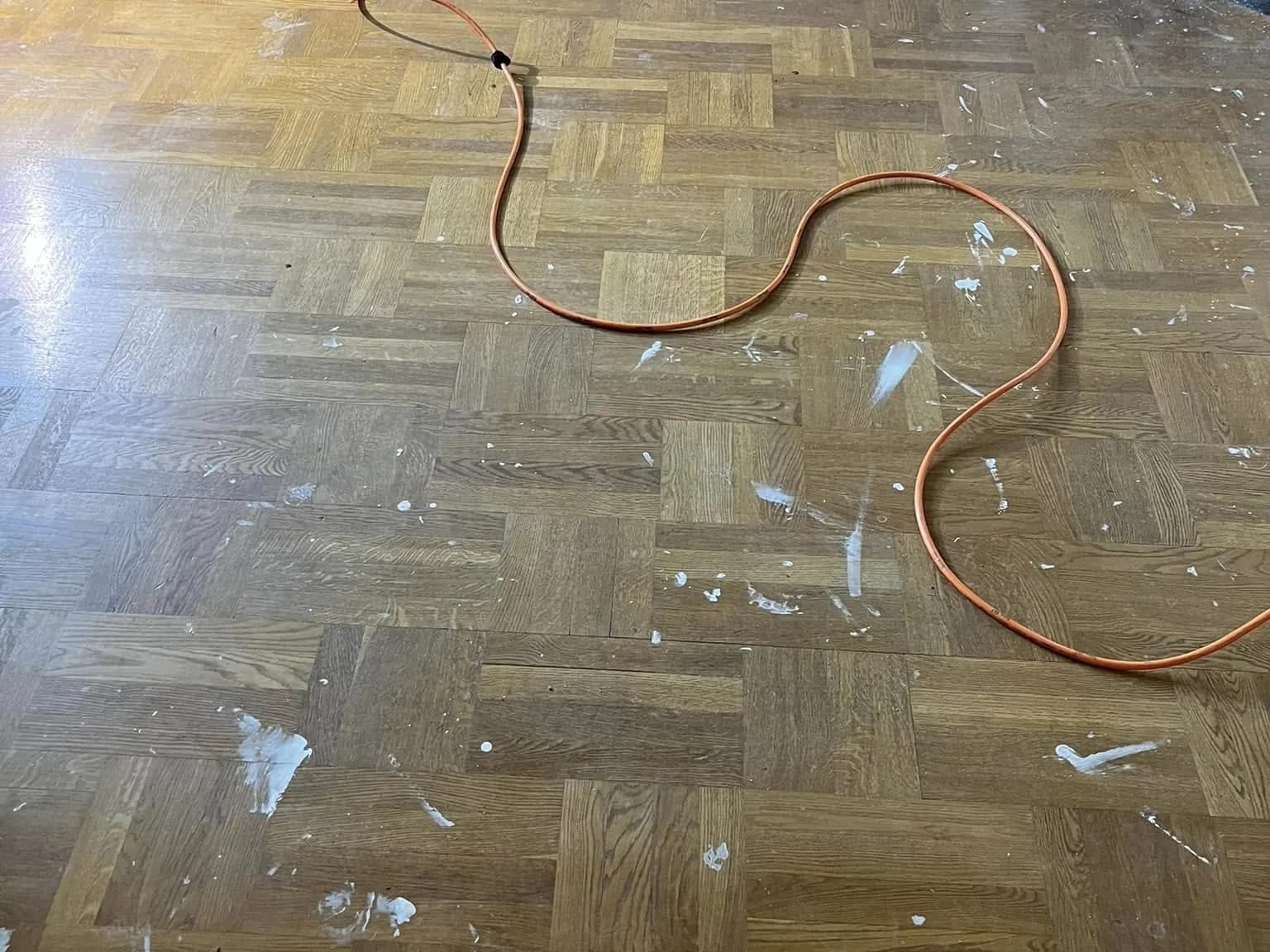 Trägolv i dåligt skick före slipning: sprickor i finish och matt yta.